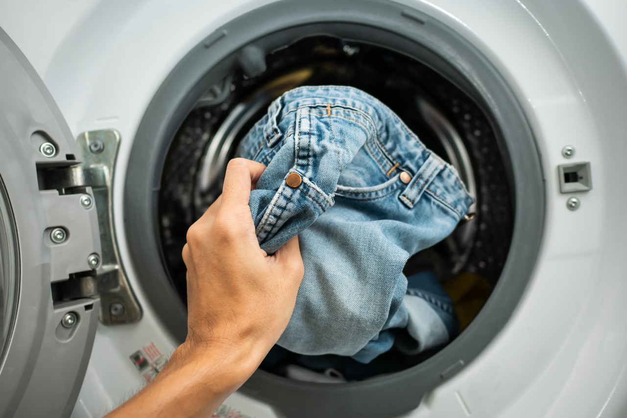 Çamaşır makinesine kot koyarak kişi